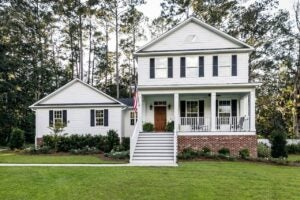 white suburban farmhouse style home exterior with american flag