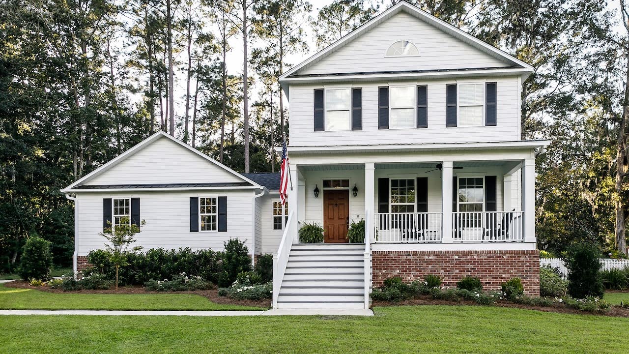 white suburban farmhouse style home exterior with american flag