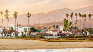 Santa Barbara beach with palm trees and city skyline at sunset, California, USA