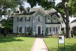 large gray and white house exterior with for sale sign in dallas tx