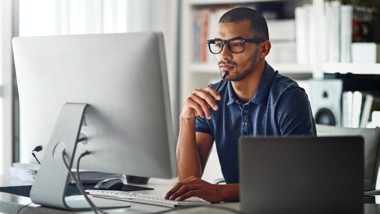 Cropped shot of a businessman using his computer in his home office