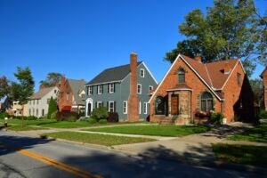 row of brick and shingle homes in the cleveland suburbs, bright blue sky