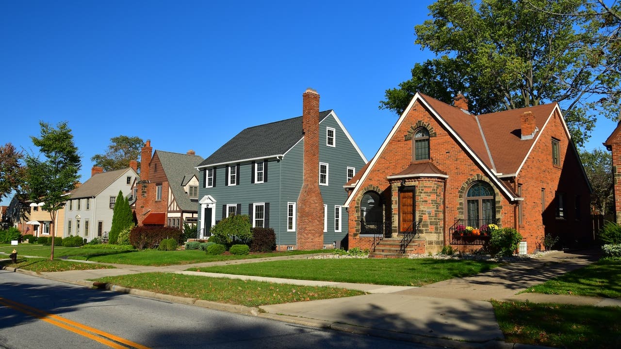 row of brick and shingle homes in the cleveland suburbs, bright blue sky