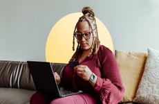 Seychelle Thomas sitting with laptop holding credit card