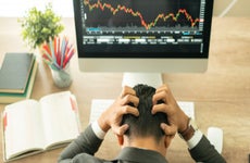 Businessman grabs the head concept with business chart on scoreboard