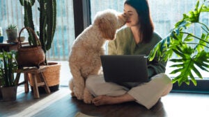 Dog sitting next to a woman