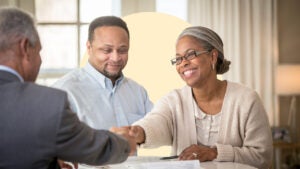 A couple shakes hands with a financial advisor.