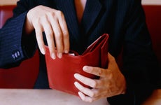 Businesswoman Opening Red Wallet at Table