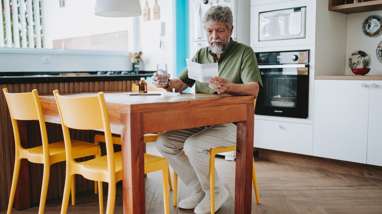 Senior man checking medical prescription at home