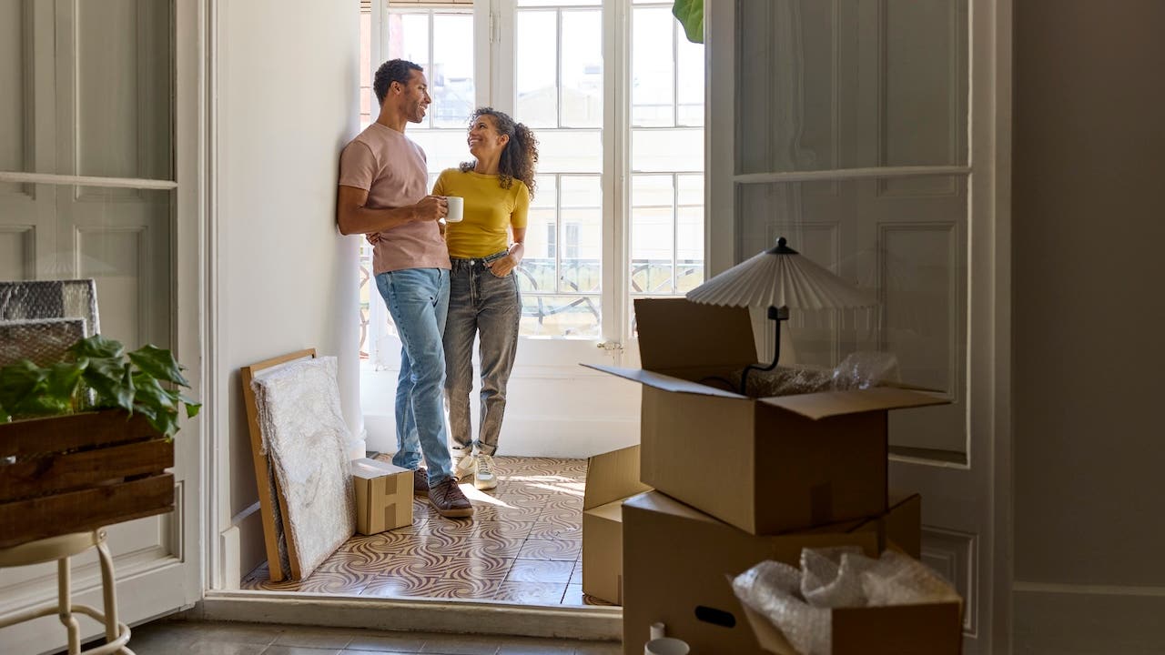 happy couple moving into their first new home, with boxes