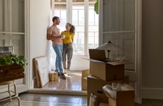 happy couple moving into their first new home, with boxes