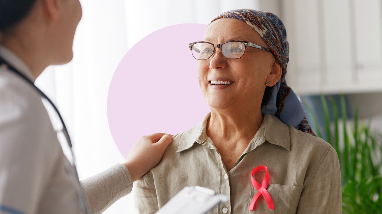 A cancer patient with a shawl over their bald scalp speaking with a doctor