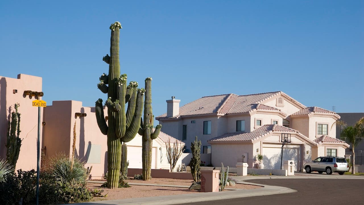 Spanish-style homes in Phoenix with saguaro cacti in front yards