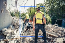 Emergency aid workers sifting through debris of a building