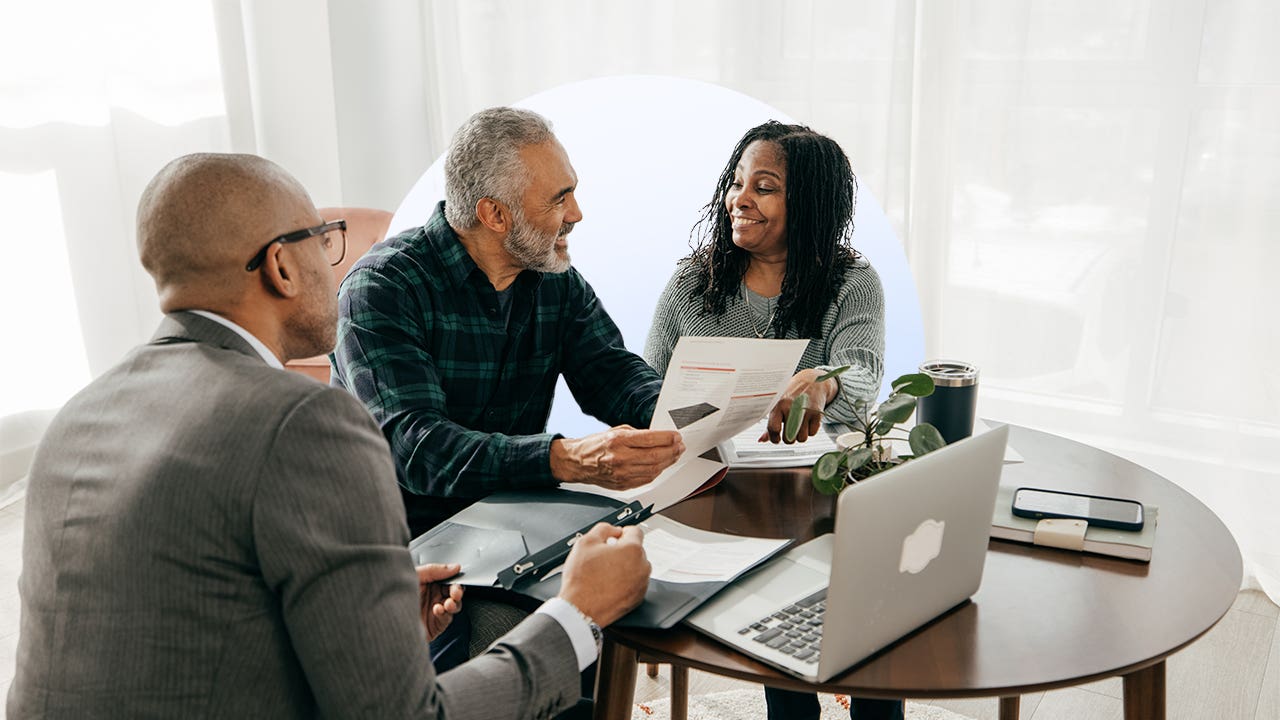 couple sitting at table working on finances with a professional