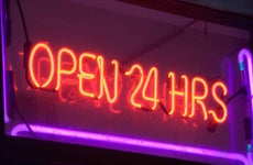 Lit neon sign reading open 24 hrs.