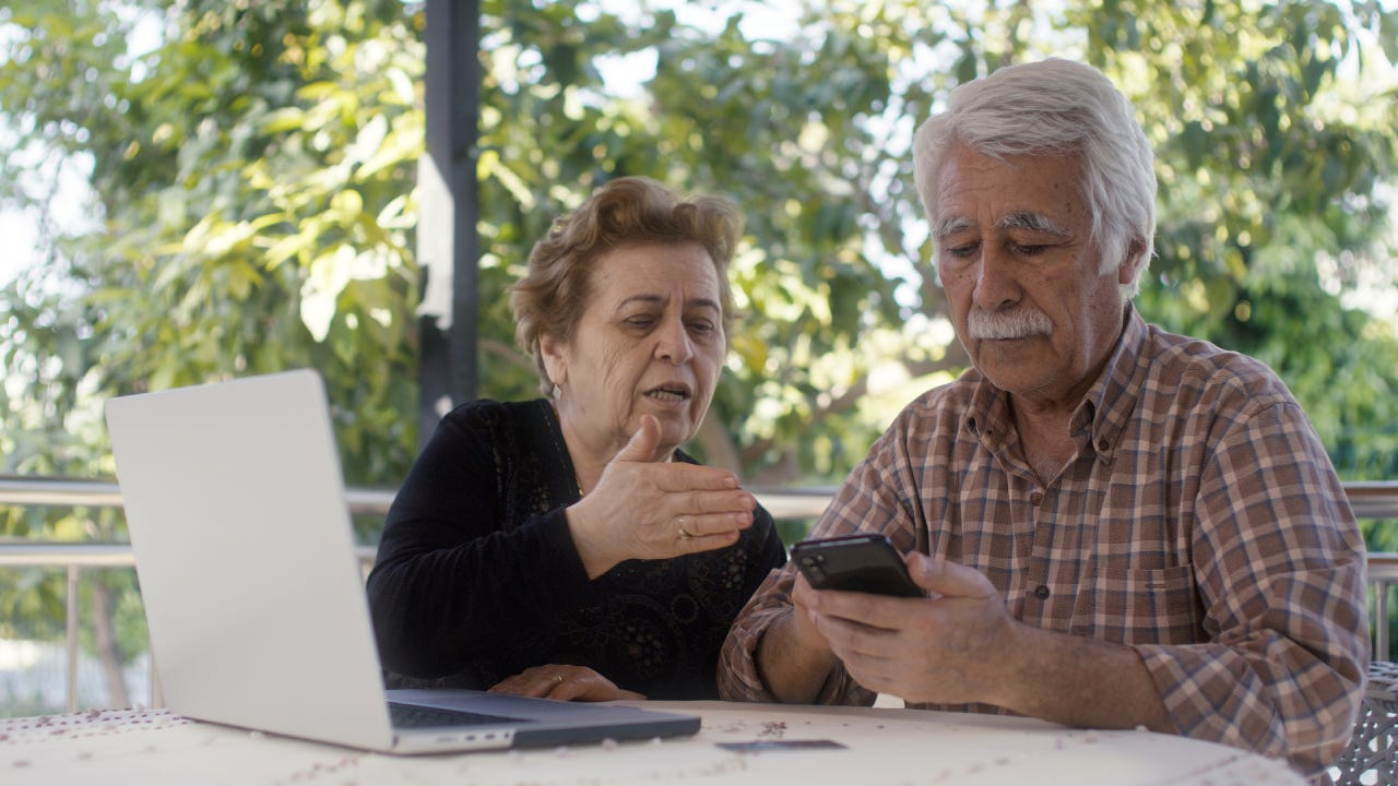 Senior couple having problem with fraud while online shopping with credit cart using laptop computer