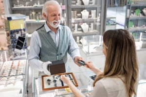 Young woman at a watch store buying with credit card