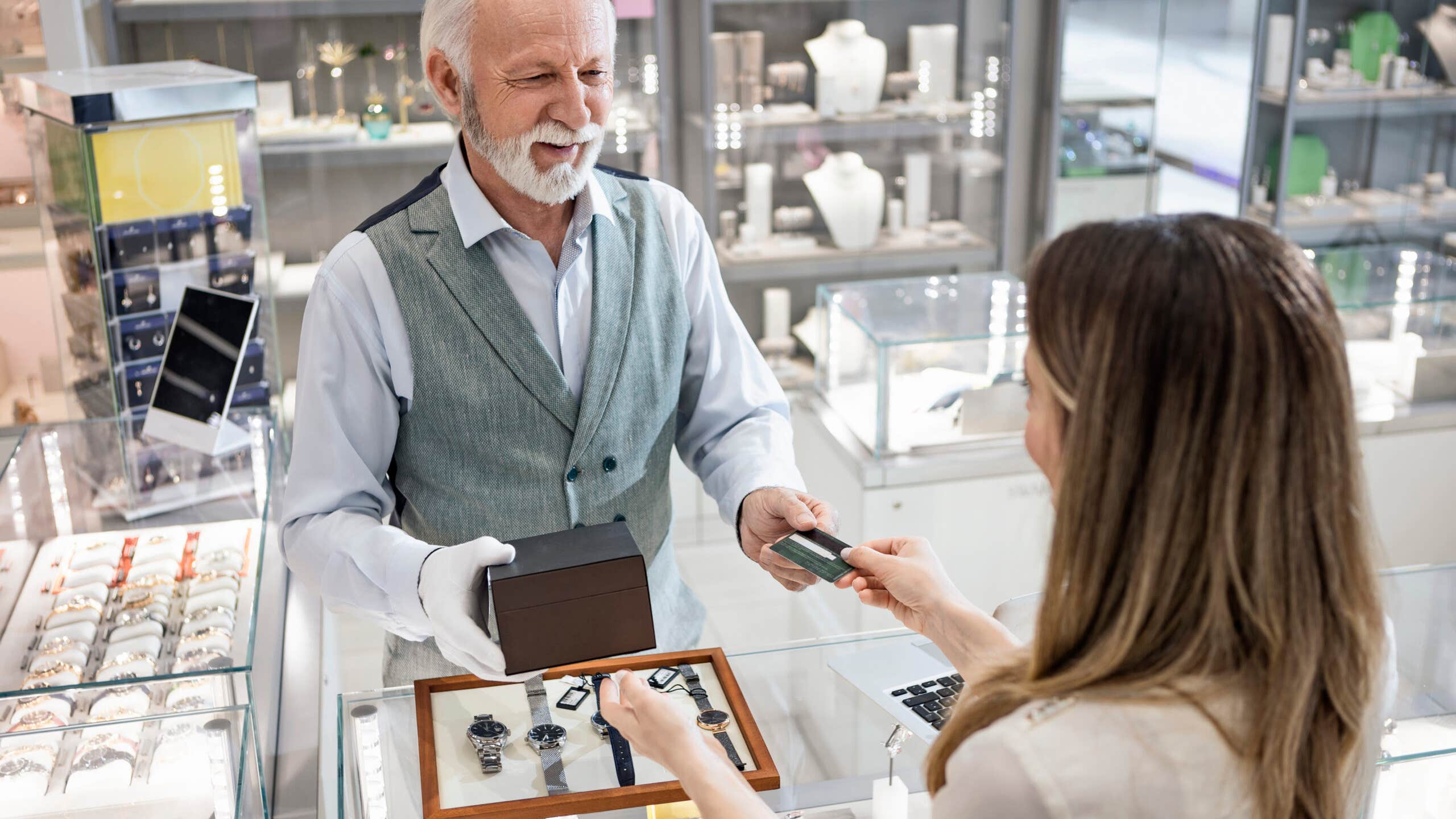 Young woman at a watch store buying with credit card