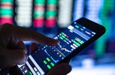 Close-up of hands of businesswoman analyzing stock market charts and key performance indicators