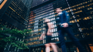 Two business people walking on downtown street. Blurred motion effect.