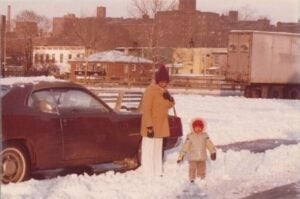 Aged photo of young girl with parent on snowy street