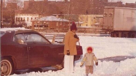 Aged photo of young girl with parent on snowy street