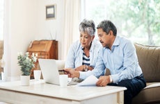 A senior couple using a laptop together at home.