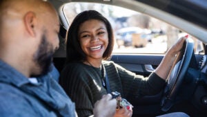 Father handing car keys to teenage daughter