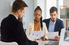 Serious married couple carefully reads paper documents