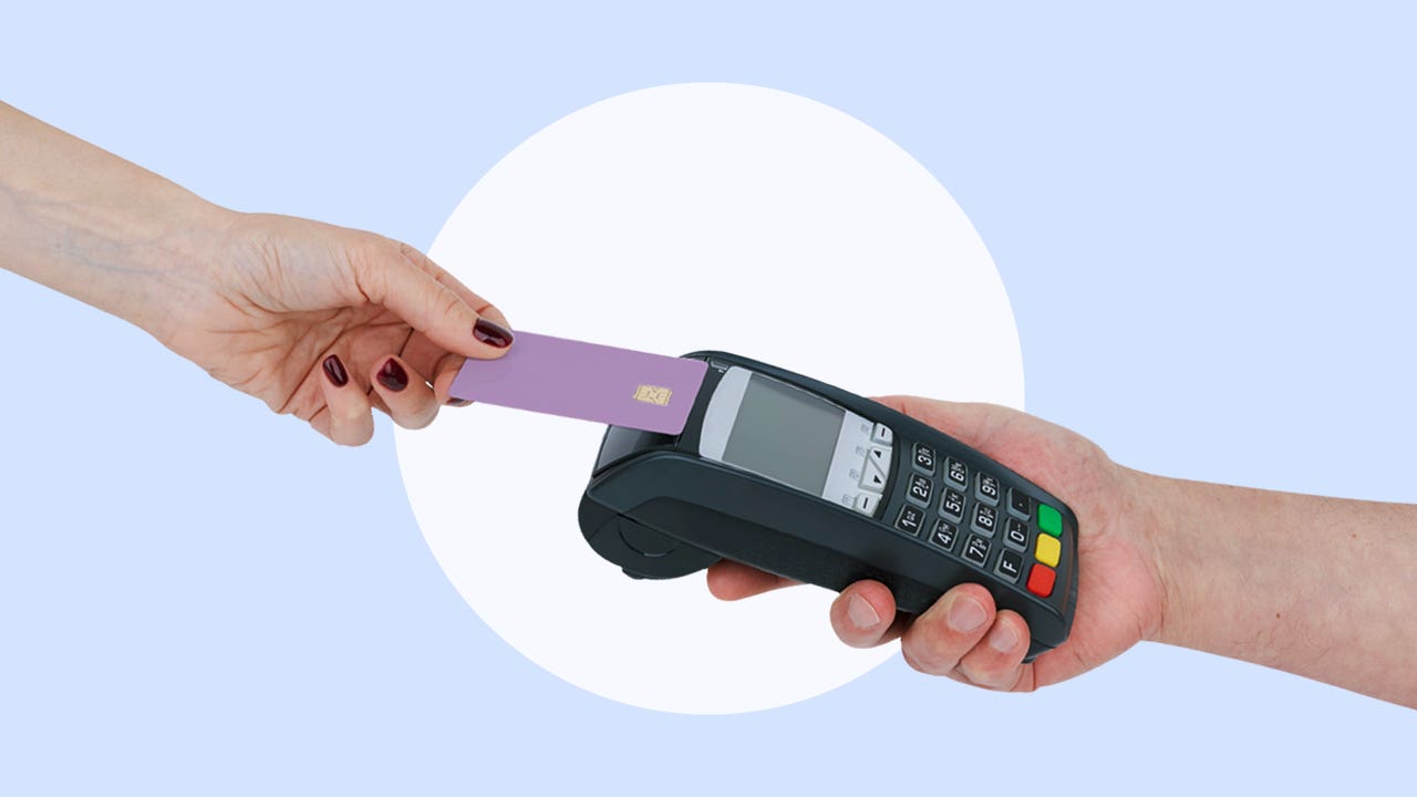 Hand tapping a credit card on a POS machine.