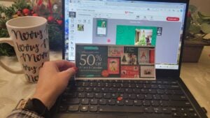 person holding coupon near computer screen