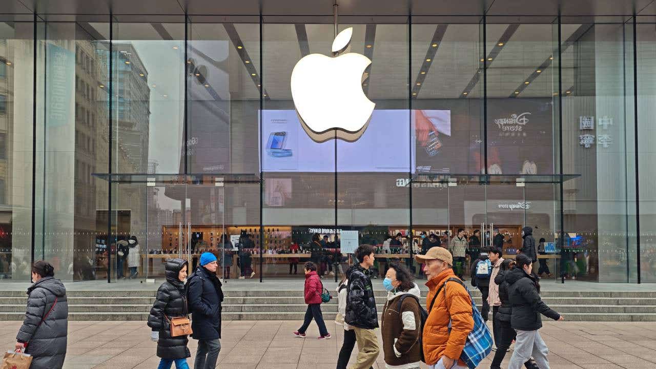 People walk in front of an Apple store.