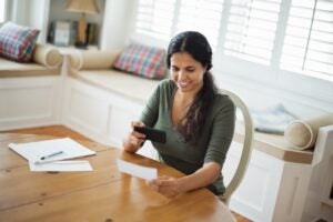 Women using smart phone to deposit check