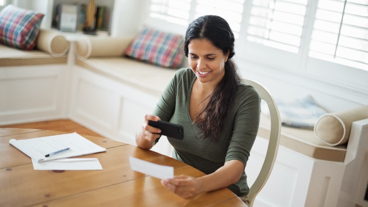 Women using smart phone to deposit check