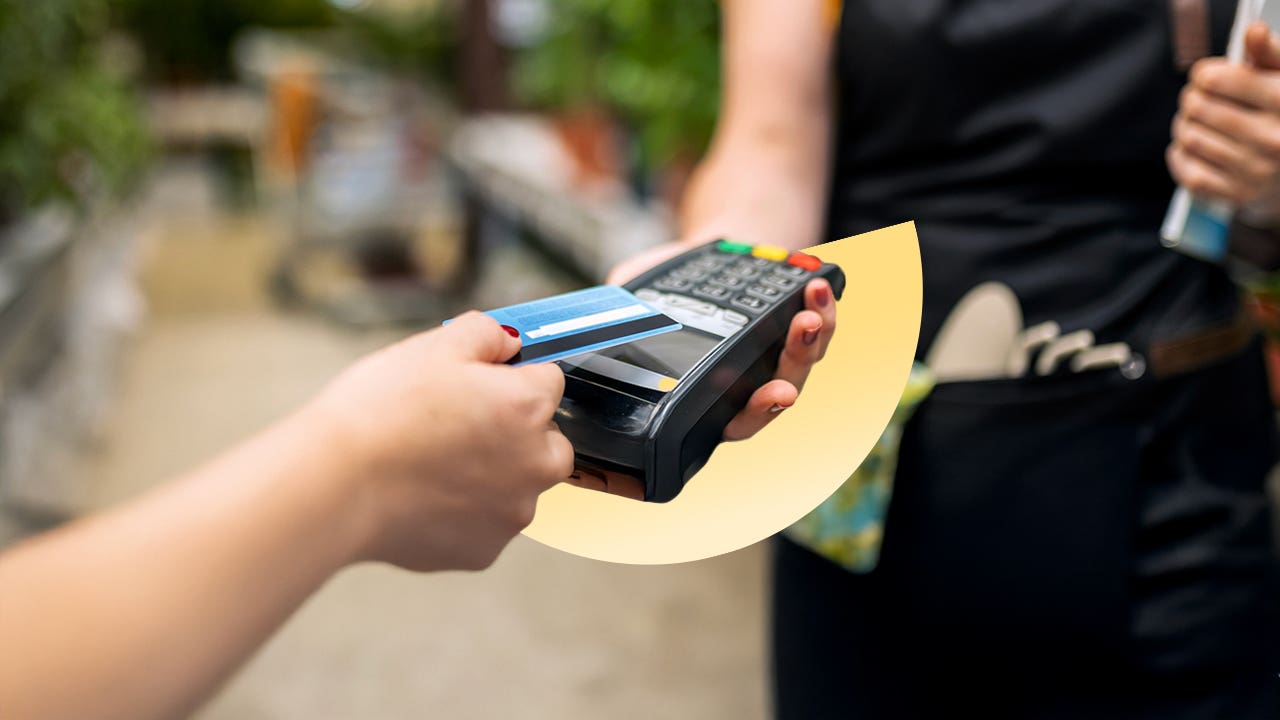 Person paying with a credit card through a handheld terminal