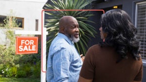 couple outside a home that's for sale, about to go inside and look around