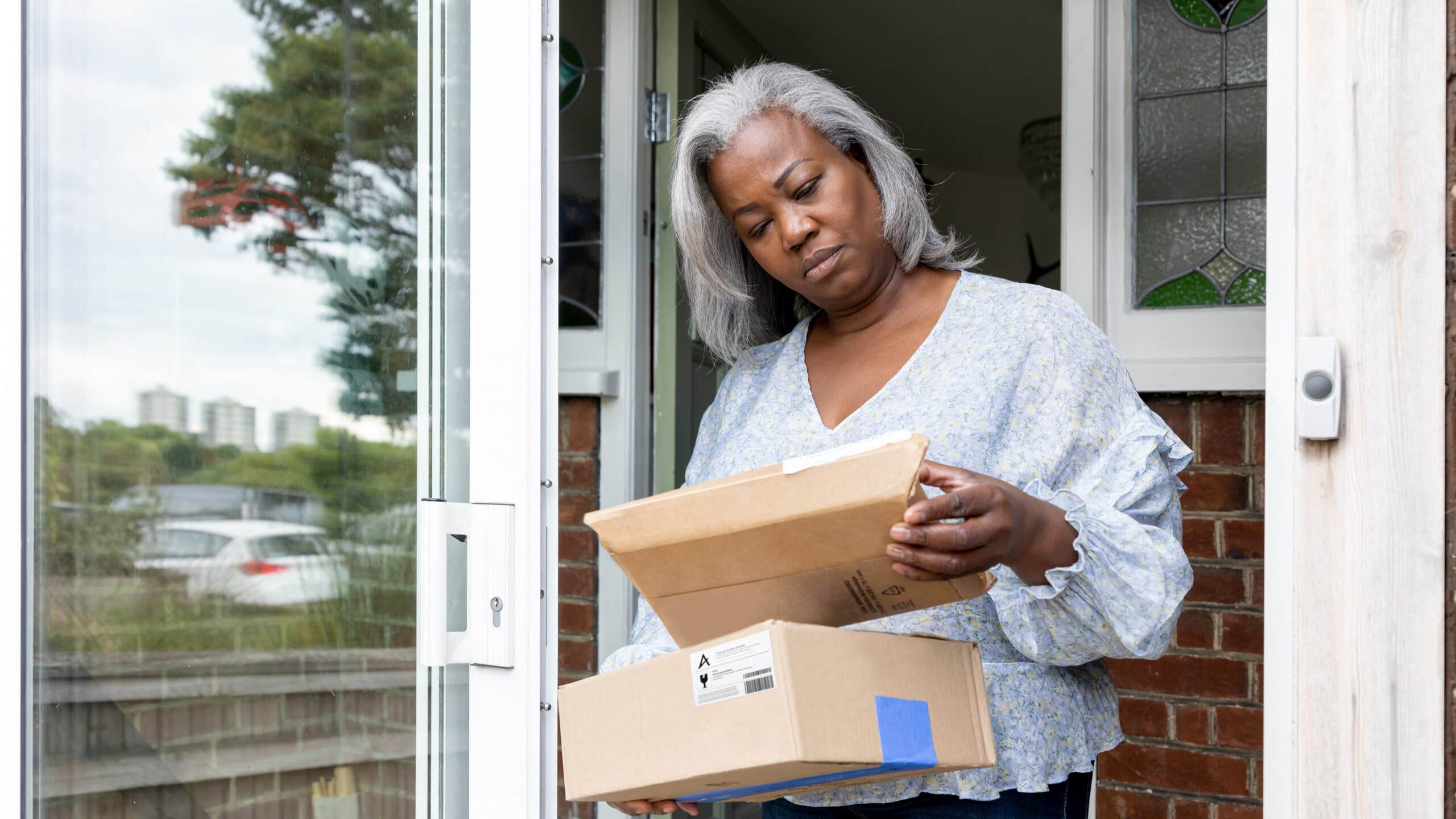 Woman at home receiving some packages and looking confused