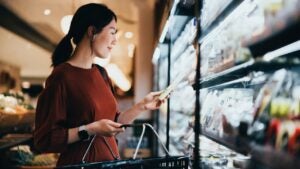 woman shopping at grocery store looking at an item