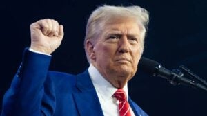 President-elect Donald Trump raises his fist while speaking.