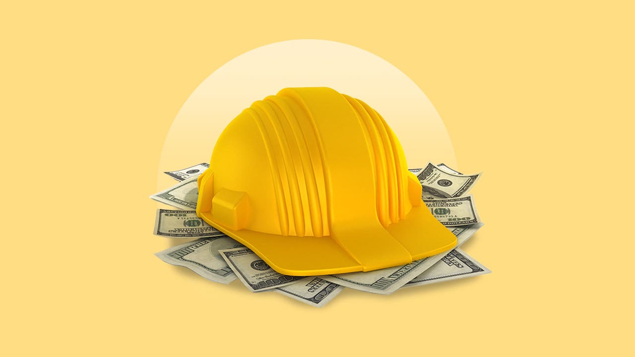 construction helmet on stack of money