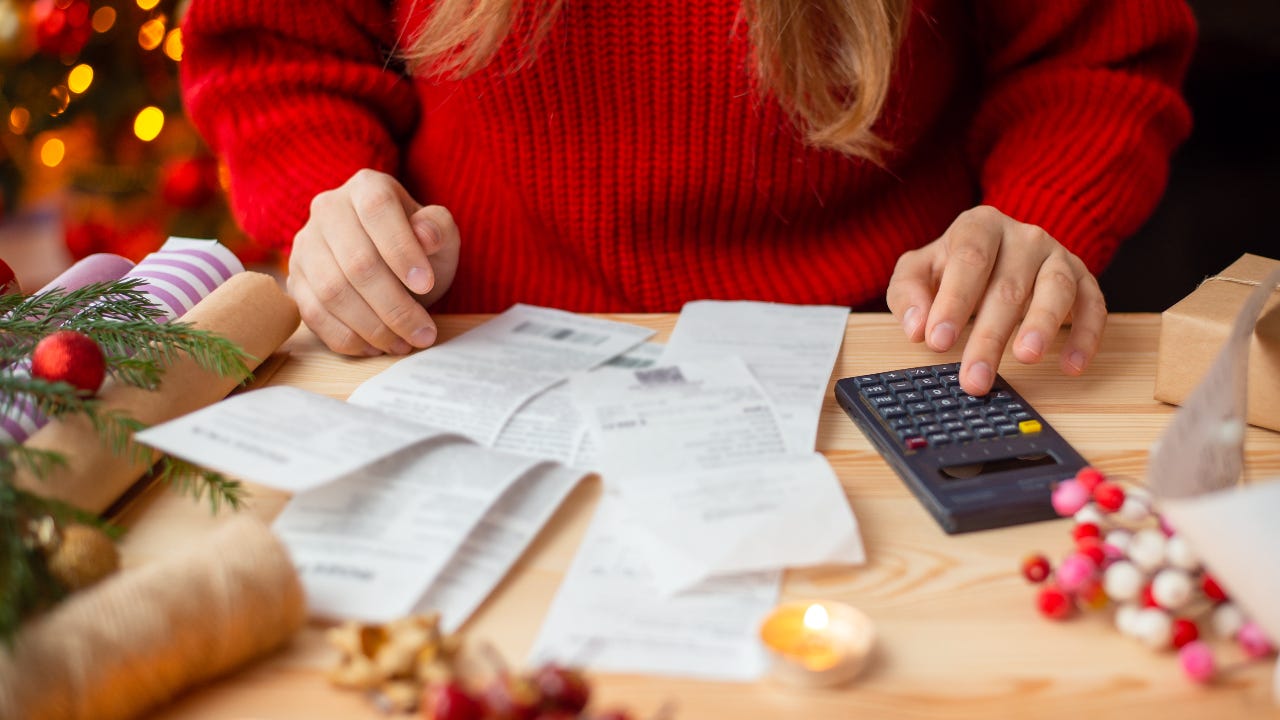 Woman sitting at the table, checking her bills after Christmas