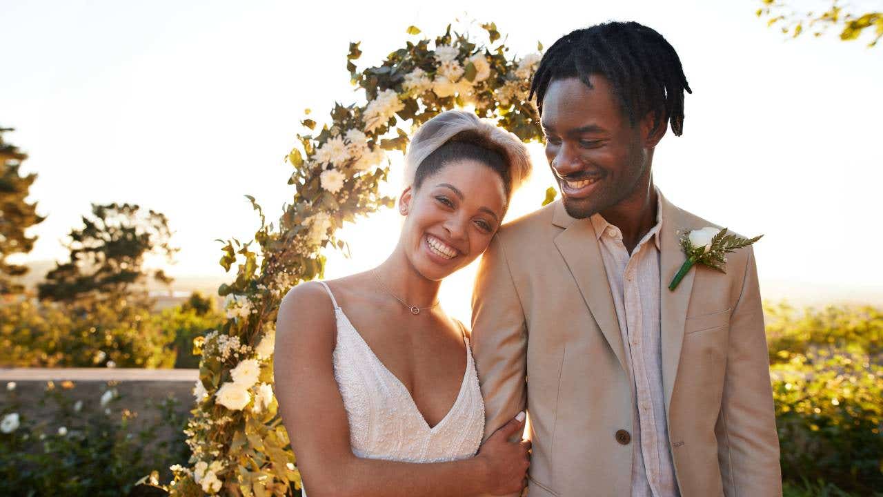 A happy couple smiles on their wedding day.