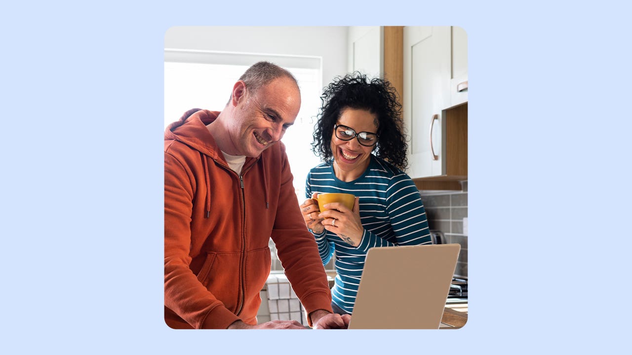 Man and women looking at a computer and smiling