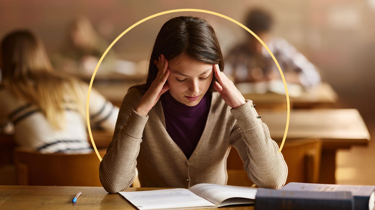 A stressed woman looks at a booklet.