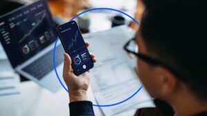 A man checks the stock market on his phone.