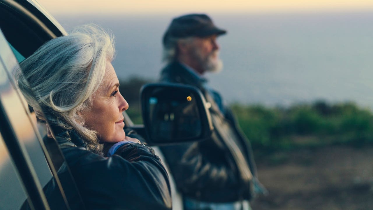 couple sitting in/by their car looking out at the ocean