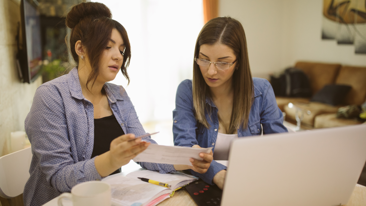 Two business owners examine tax douments.