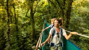 mother with her child on her back hiking through a forest