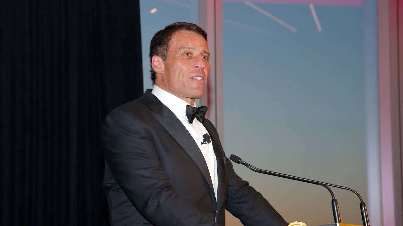 Tony Robbins speaks at a podium.